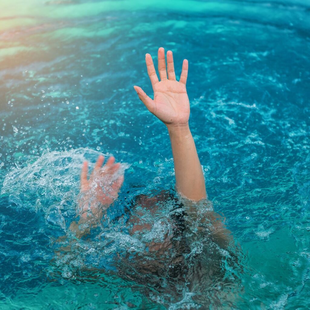 a man waving his hand for help to save him from drowning
